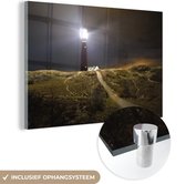 MuchoWow® Glasschilderij 90x60 cm - Schilderij acrylglas - Een verlichte vuurtoren op het eiland Schiermonnikoog - Foto op glas - Schilderijen
