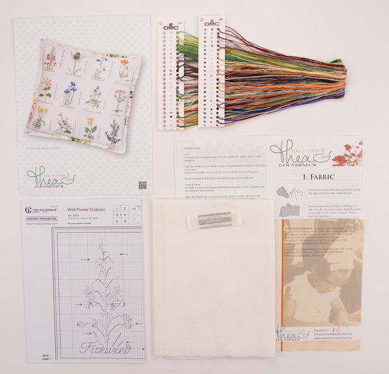 Un kit de point de croix comprenant un tissu à motif floral, des fils DMC, un diagramme et une aiguille.