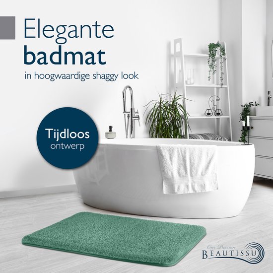 Groene shaggy badmat in een moderne badkamer, bij een vrijstaand bad.