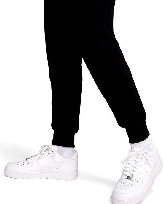 Zwarte Nike joggingbroek met witte Nike sneakers en sokken.