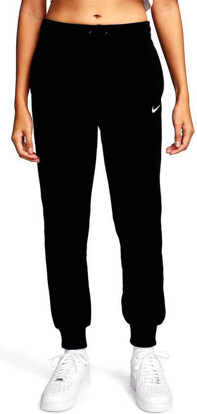 Voorkant van zwarte joggingbroek met wit Nike logo, witte sneakers en witte sokken.
