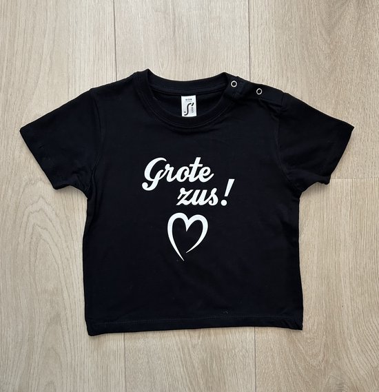 Zwart kinder T-shirt met witte tekst "Grote zus!" en een hart.