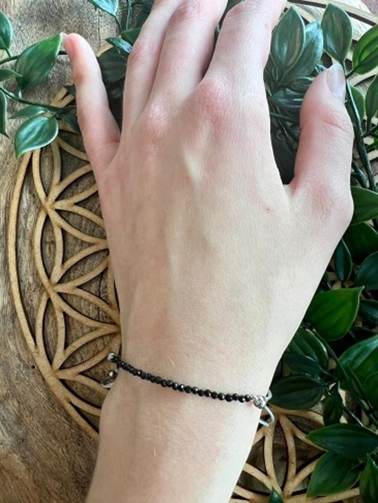 Zwarte facet geslepen kristallen armband met zilverkleurige details om een pols.