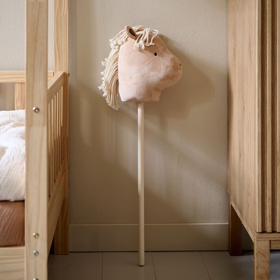 Een lichtbruin houten stokpaardje met witte manen.