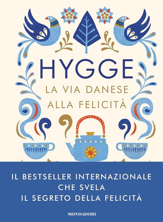 Couverture de livre avec "HYGGE LA VIA DANESE ALLA FELICITÀ" en lettres bleues, décorée d'oiseaux, de plantes et d'une théière.
