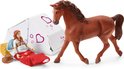 Bruin paard naast een openklapbare witte tent met roze hartjes. Meisje slaapt in rode slaapzak.