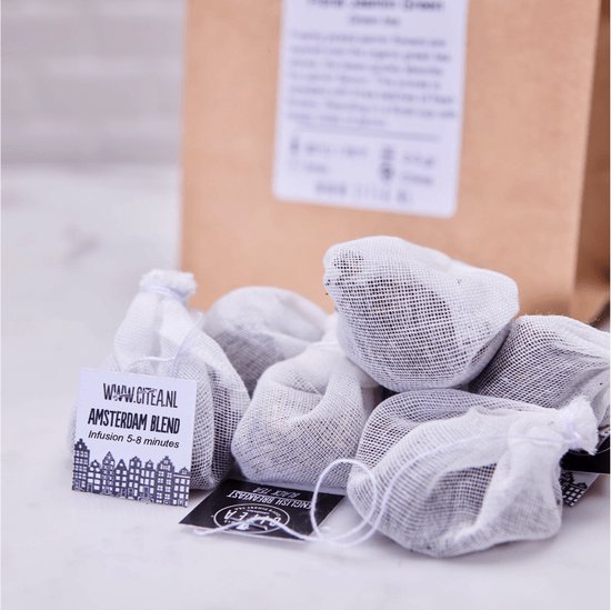 Een bruine papieren zak met veel witte theezakjes. Op de voorgrond een kaartje met 'Amsterdam Blend' en de tekst 'www.citea.nl'.