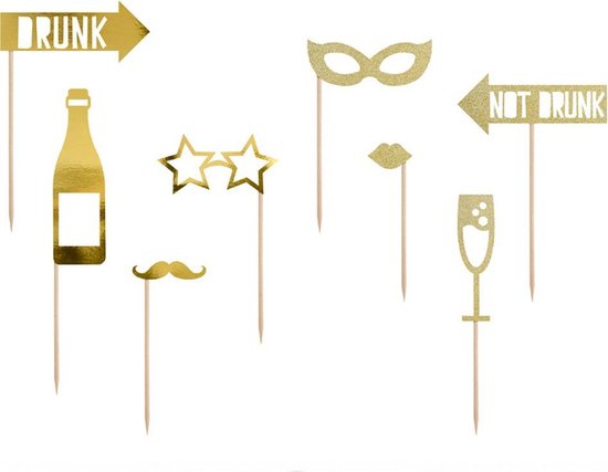 Gouden feestattributen: fles, snor, bril, masker, lippen, champagneglas, en bordjes 'DRUNK' en 'NOT DRUNK'.