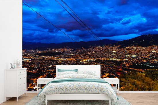 Behang - Fotobehang Uitzicht vanaf het kabelbaan station over Medellin met een blauwe hemel - Breedte 420 cm x hoogte 280 cm