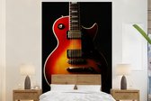 Behang - Fotobehang Een roodkleurige elektrische gitaar - Breedte 170 cm x hoogte 260 cm