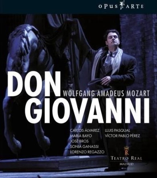 Don Giovanni, Wolfgang Amadeus Mozart. Een man in een grijs pak met sjaal staat naast een standbeeld.