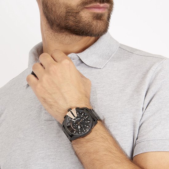 Man met grijs poloshirt draagt een zwart Diesel Mega Chief horloge met roségouden accenten.