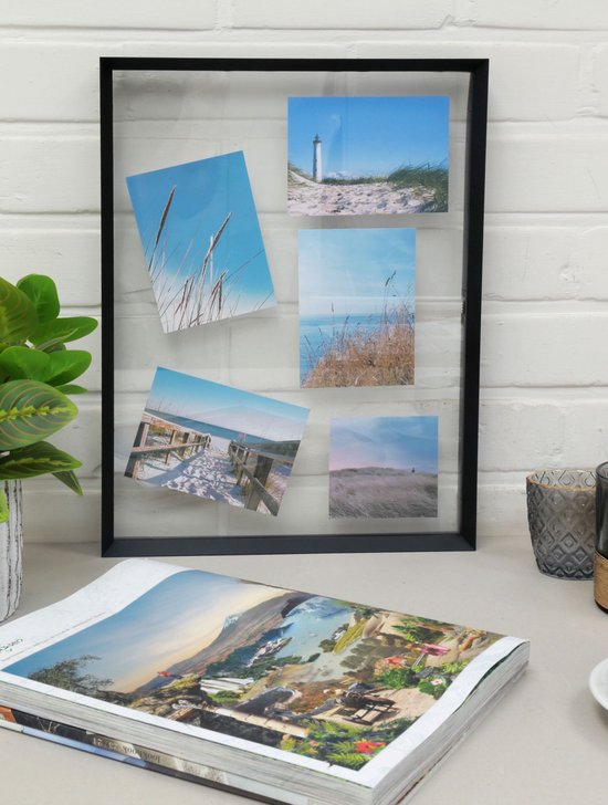 Zwarte fotolijst met 4 strandfoto's, staand op een bureau