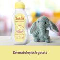 Vader speelt met lachende baby in gele trui, met Zwitsal huidolie en zalf in de achtergrond.