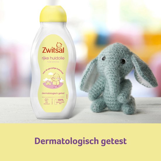 Vader speelt met lachende baby in gele trui, met Zwitsal huidolie en zalf in de achtergrond.