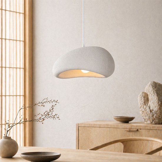 Lampe suspendue blanc aspect pierre, forme organique, avec source lumineuse visible, lumière tamisée.