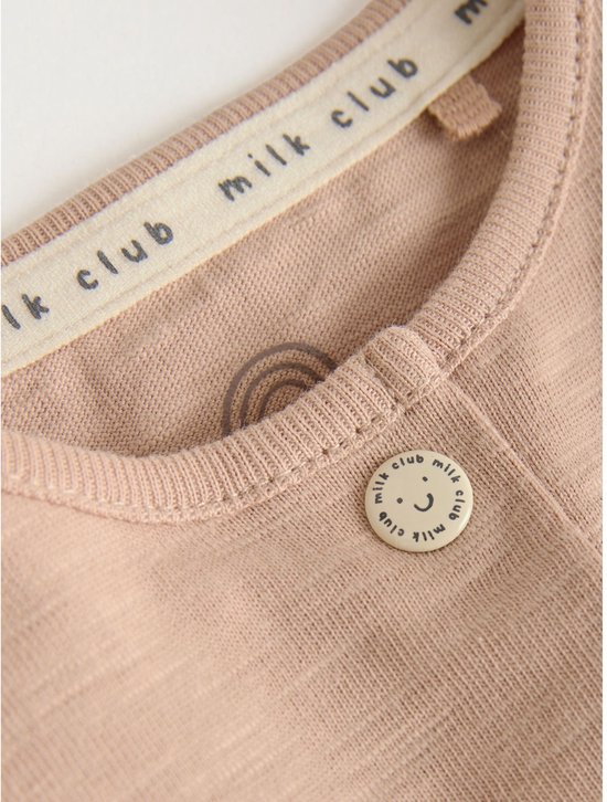 Close-up van de kraag en knoop van een lichtroze romper met 'milk club' tekst en een smiley.
