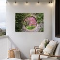Vue d'un cerisier sakura en fleurs à travers un cercle de pierre. Accroché à un mur blanc sur un balcon.