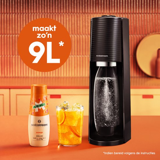 Zwarte SodaStream machine met Mirinda fles en glas bruisend drankje.