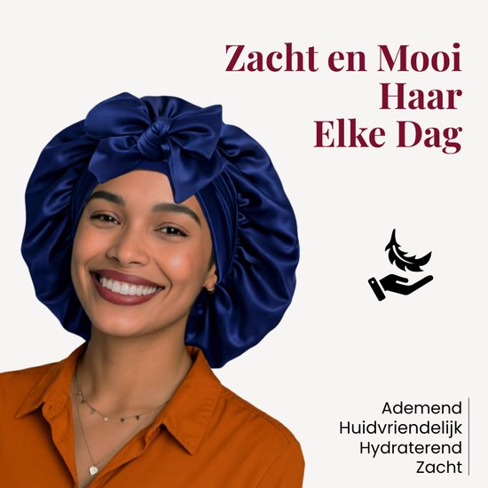 Model met een glimlach die een donkerblauwe satijnen slaapmuts met strik draagt. Zacht, ademend en hydraterend.
