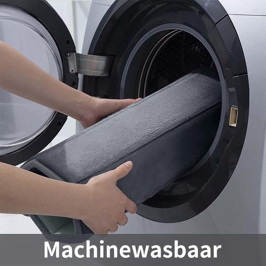 Grijze badmat wordt in een wasmachine geplaatst.
