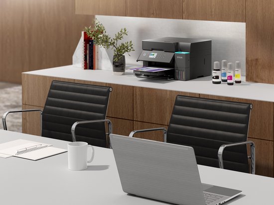Zwarte Epson EcoTank printer met inktflessen (zwart, cyaan, magenta, geel) op een bureau.