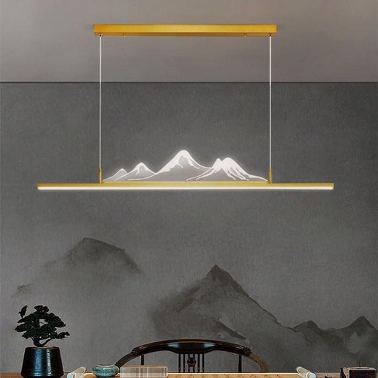 Gouden lineaire kroonluchter met verlichting die een berglandschap uitstraalt, boven een eettafel.