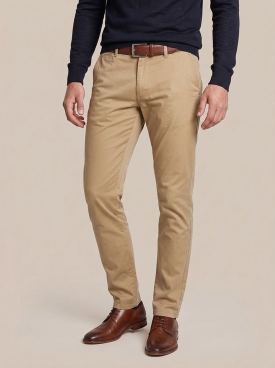 Man met donkerblauwe trui, bruine riem en lichtbruine chino broek.