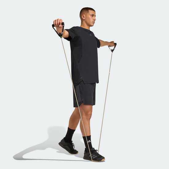 Man met zwart Adidas performance shirt met korte mouwen, die een weerstandsband gebruikt.