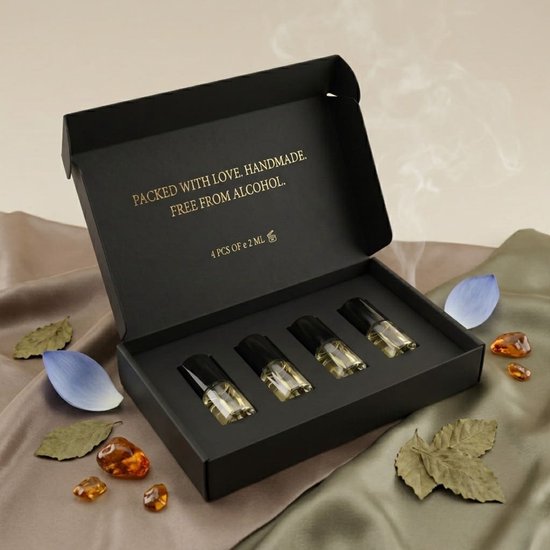 Zwarte geschenkdoos met vier kleine parfumflesjes, 'Packed with love. Handmade. Free from alcohol.' staat erop.
