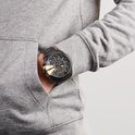 Zwart Diesel Mega Chief herenhorloge met gouden details, gedragen door een man met grijze hoodie.