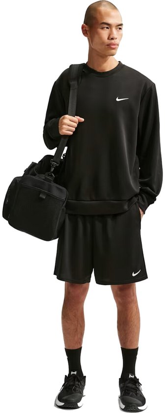 Man met zwarte trainingsbroek, trainingsshirt en sporttas.