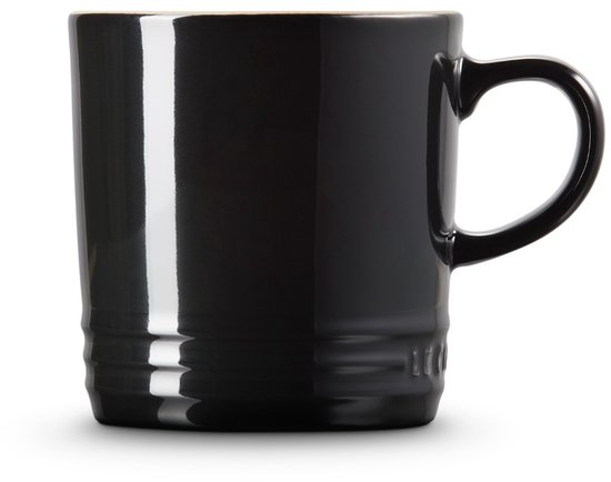 Mug Le Creuset noir à l'intérieur beige, présenté sur fond blanc.