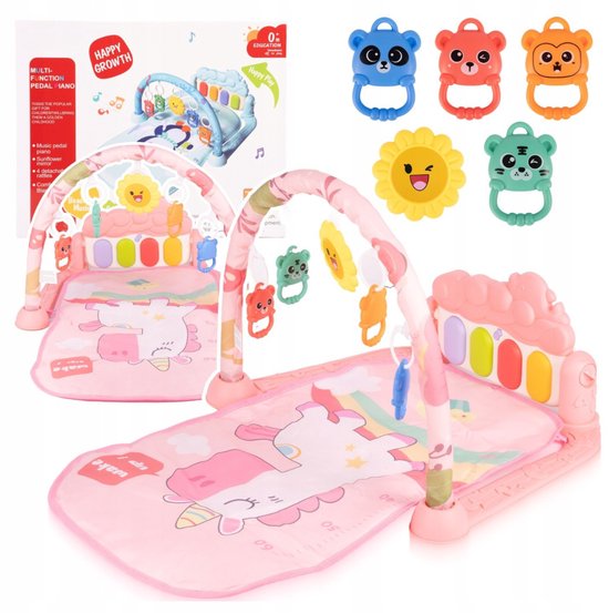 Roze speelmat met eenhoorn en boog, met diverse rammelaars en een piano. Een verpakkingsdoos met een babygym wordt ook getoond.