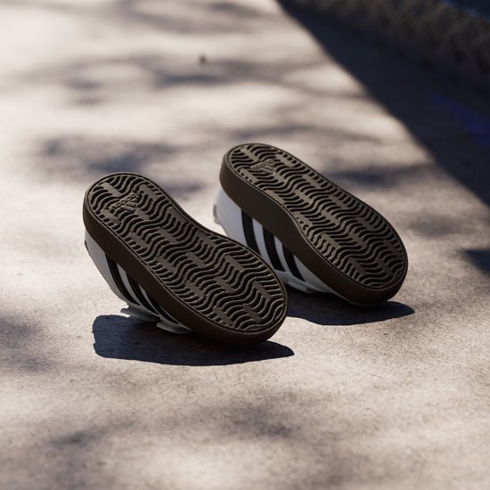 Wit met zwarte strepen, de zolen van deze kinderschoenen zijn grijs met golvend patroon.