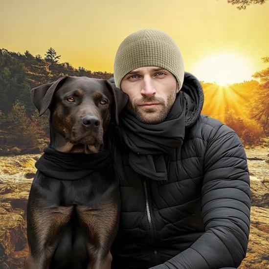 Man met beige beanie en zwarte sjaal, naast een hond.