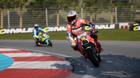 Coureur in rood en blauw pak, nummer 10, op rode motor, scherpe bocht op circuit.