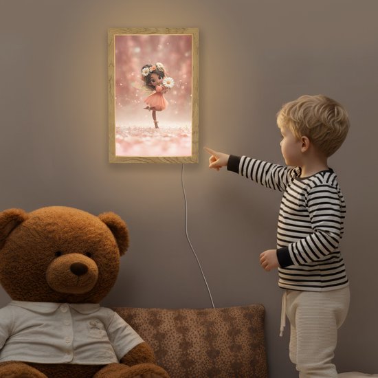 Kind wijst naar een oplichtende lamp met een fee op de muur in een kinderkamer, naast een teddybeer.