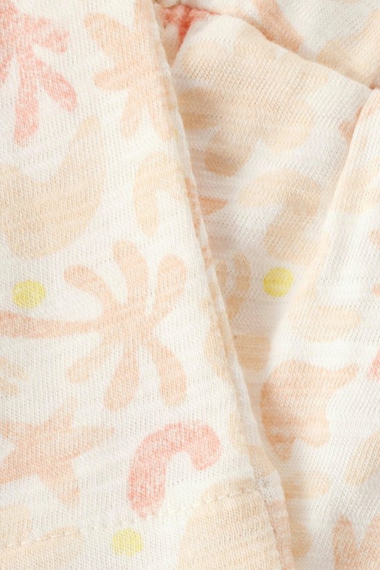 Detail van crème stof met lichtroze en oranje botanische print.
