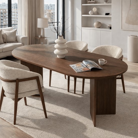 Ovale eettafel van donker hout met vier beige stoffen stoelen met houten frame.