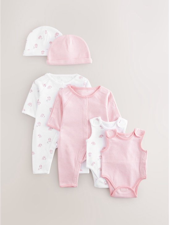 Set van premature babykleding: pyjama's, rompertjes en mutsjes met roze konijntjes of roze strepen.