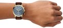 Gouden Fossil horloge met blauwe wijzerplaat en bruine leren band gedragen om een pols.