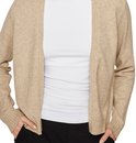 Lichtbeige gebreid vest met lange mouwen, gedragen over een wit shirt en zwarte broek, met handen in de zakken.