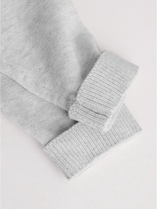 Detail van de opgerolde gebreide manchetten van een lichtgrijs babyvestje.