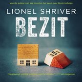 Boek "Bezit" van Lionel Shriver. Twee houten huisjes, één staand, één omgevallen.