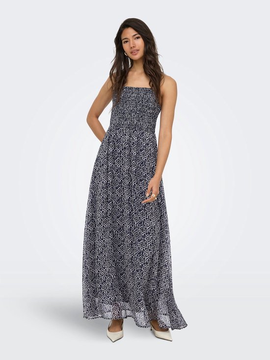 Maxi jurk met spaghettibandjes en gerimpeld lijfje in marineblauw met een witte geometrische print, gedragen door een vrouw.
