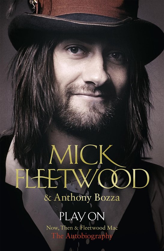 Mick Fleetwood met lange bruine haren en baard, draagt een bruine hoed, vest en een gouden ketting. Titel: PLAY ON.