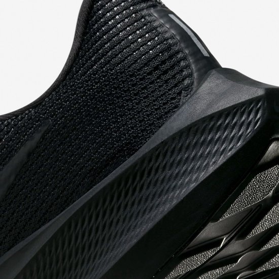 Close-up van de zwarte, textuur hiel en zool van een Nike sportschoen.