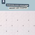 Detail van een witte douchemat met een ruitpatroon en drainagegaten.