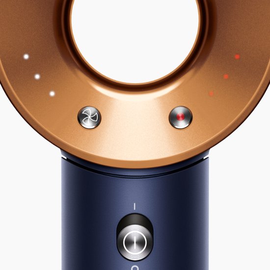 Close-up van de haardroger met koperkleurige kop, blauwe body, en aan/uit-knop. Met LED-indicatoren.